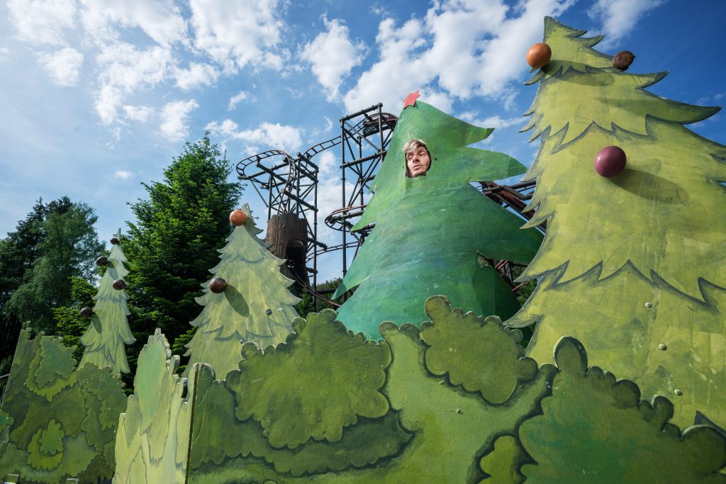 Un homme sapin se cache au milieu des sapins