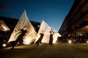 Spectacle avec une personne qui court avec une grande bâche de plastique
