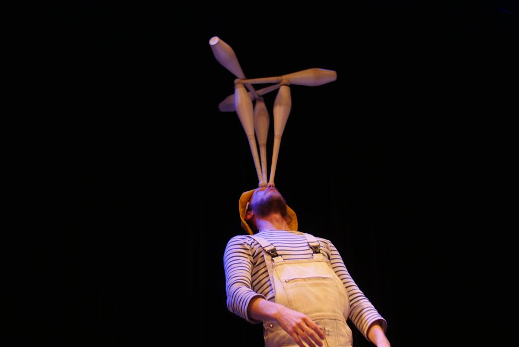 Jongleur avec 6 massues en équilibre